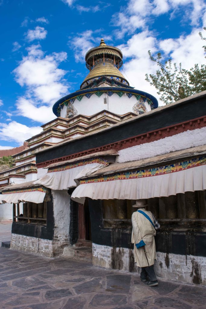 Peregrino girando as rodas de oração durante a kora no Gyantse Monastery, em Shigatse.