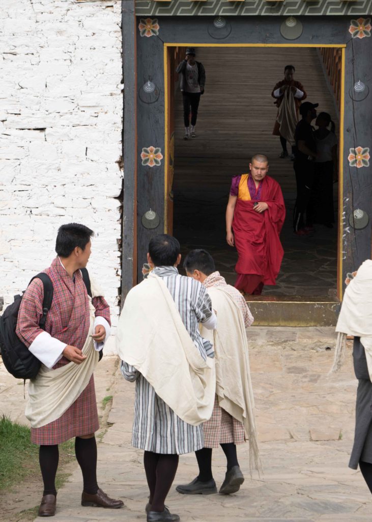 Homens butaneses em horário de trabalho com suas roupas tradicionais, o Gho, faixa, meia e sapato.