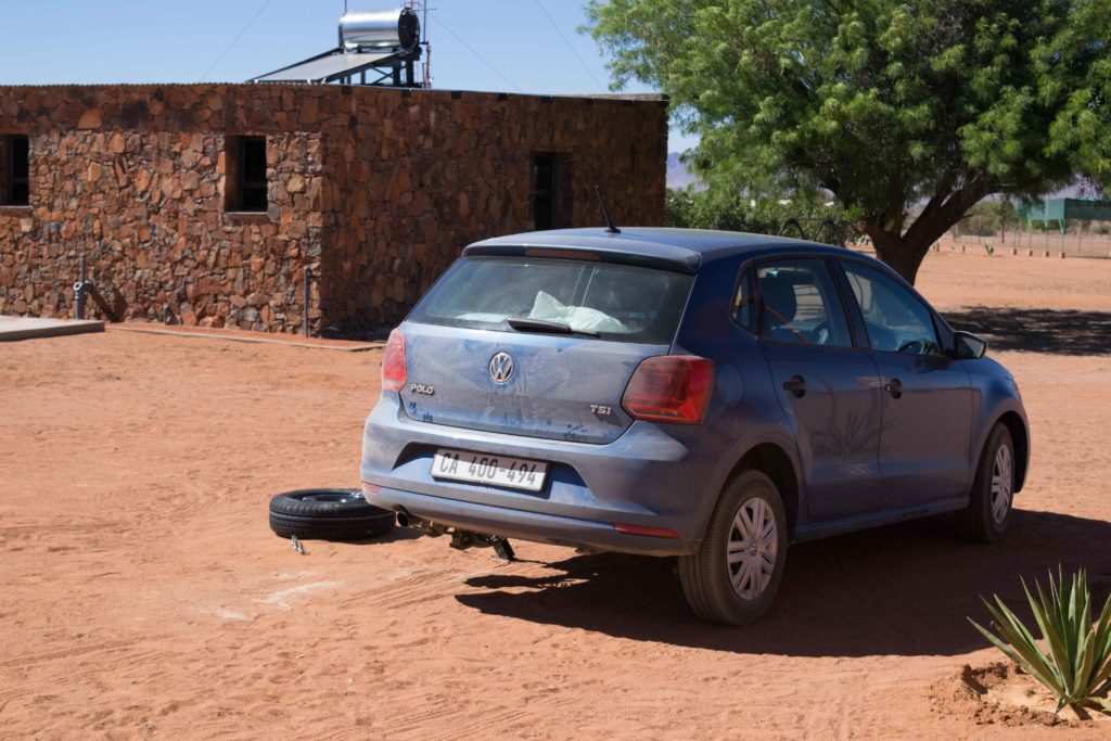 Viagem para a Namíbia. Trocando nosso primeiro pneu furado depois de 250kms de estrada de terra cheia de pedras. Pelo menos furou na porta do camping!