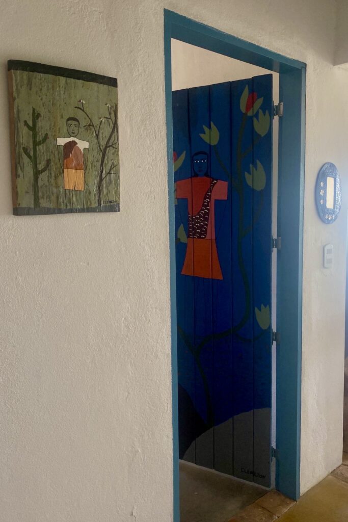 Obras de Clemilton (porta e quadro) e seu Beto de Meirus (espelhinho) na Casa Olivia.
